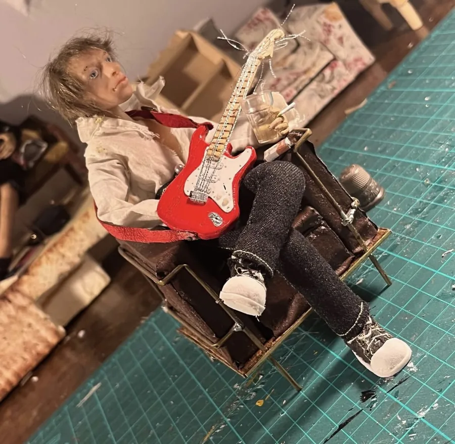 Puppet with a miniature red guitar