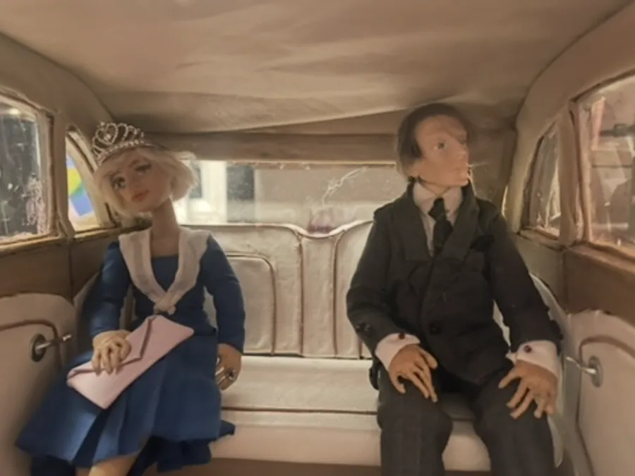 Two characters seated in a car