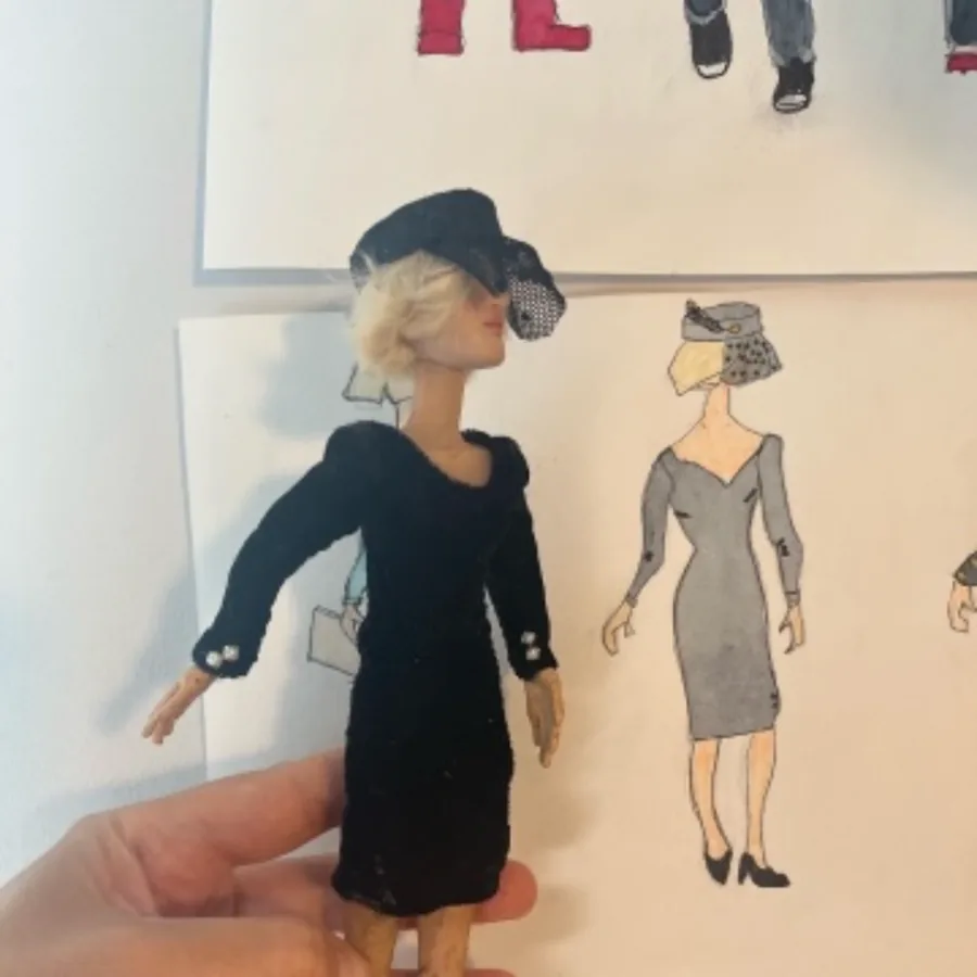 Costumed puppet beside her character sketch