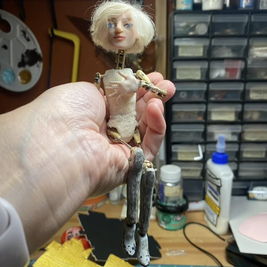 A puppet held in front of the workshop