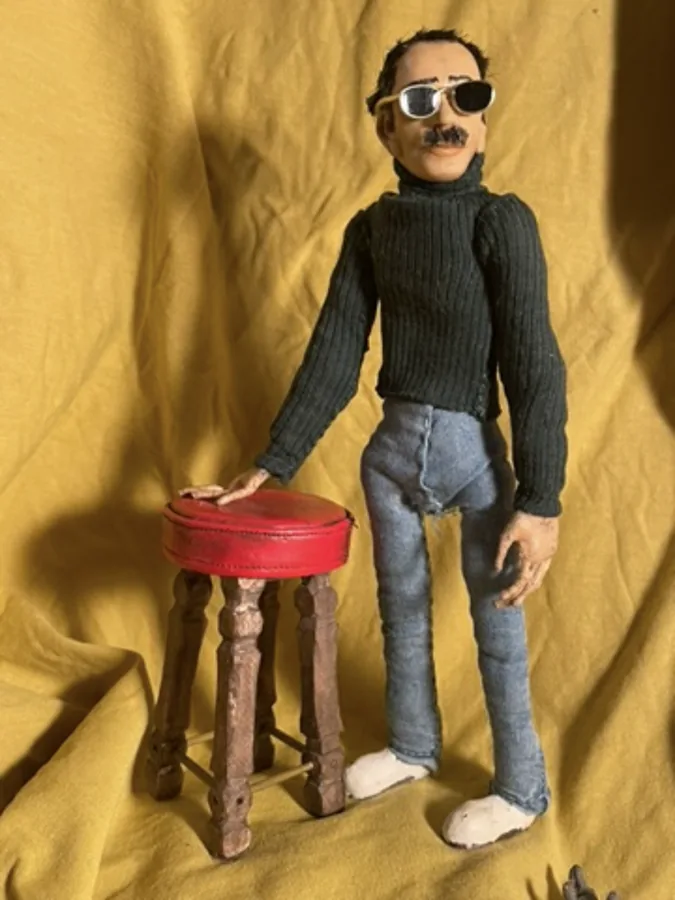 Puppet posed against golden curtains