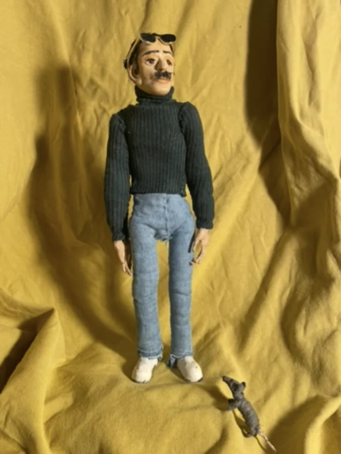 Another puppet pose against golden curtains