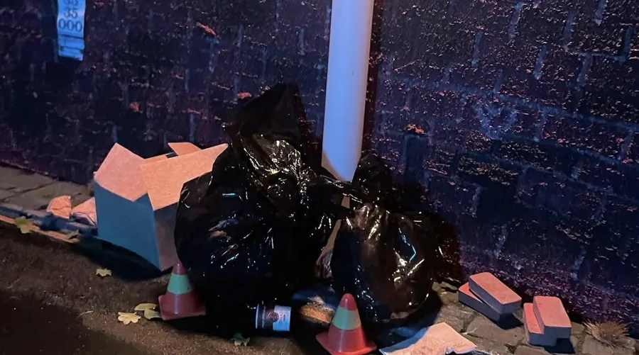 Miniature rubbish bags, boxes and traffic cones beside a street pole